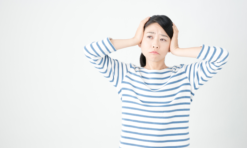 頭を抱えて困る女性