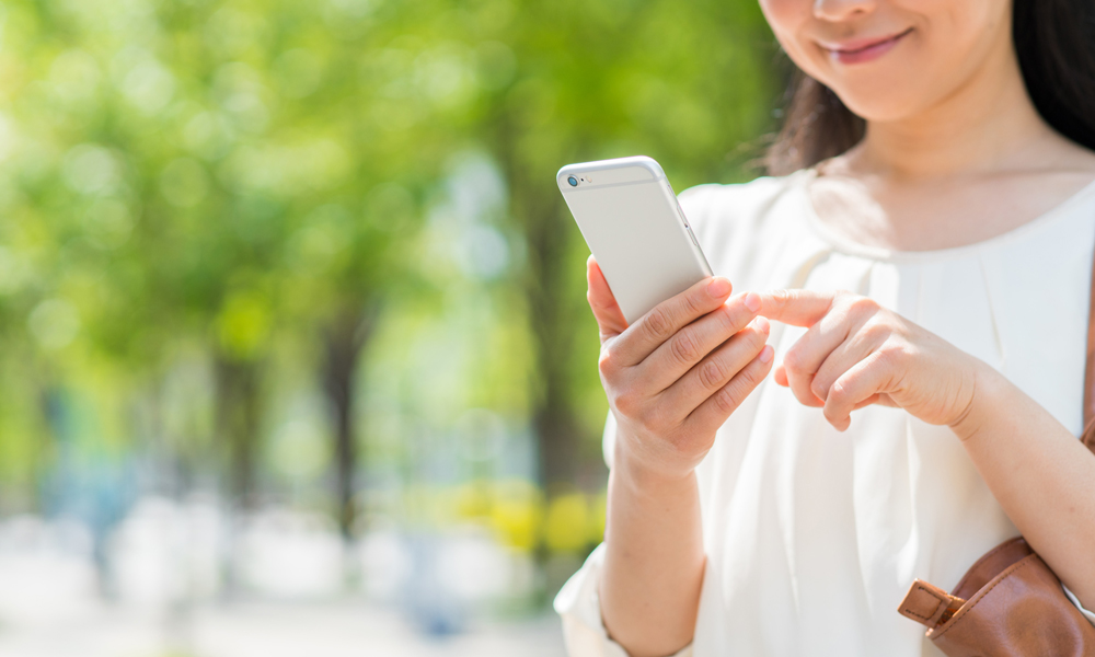 屋外でスマホを操作する女性