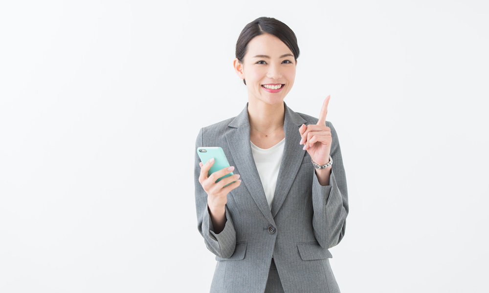 スマホを片手にポイントを示唆するキャリアウーマン