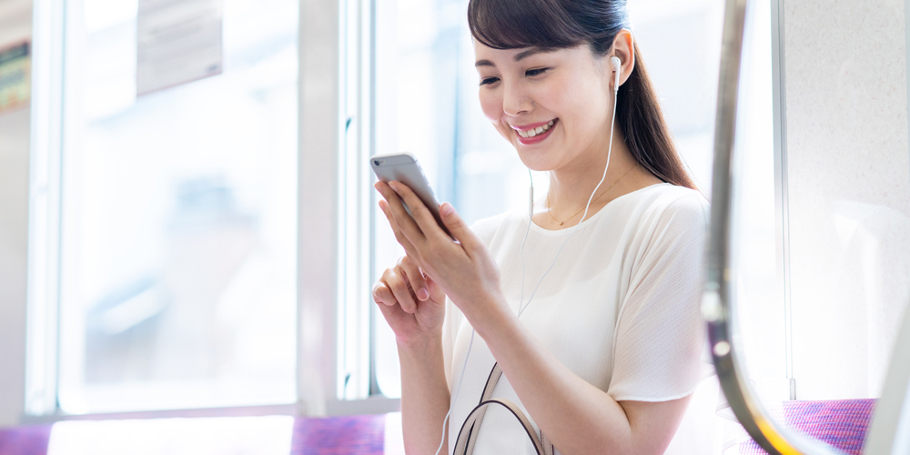 電車内でスマホをいじる女性