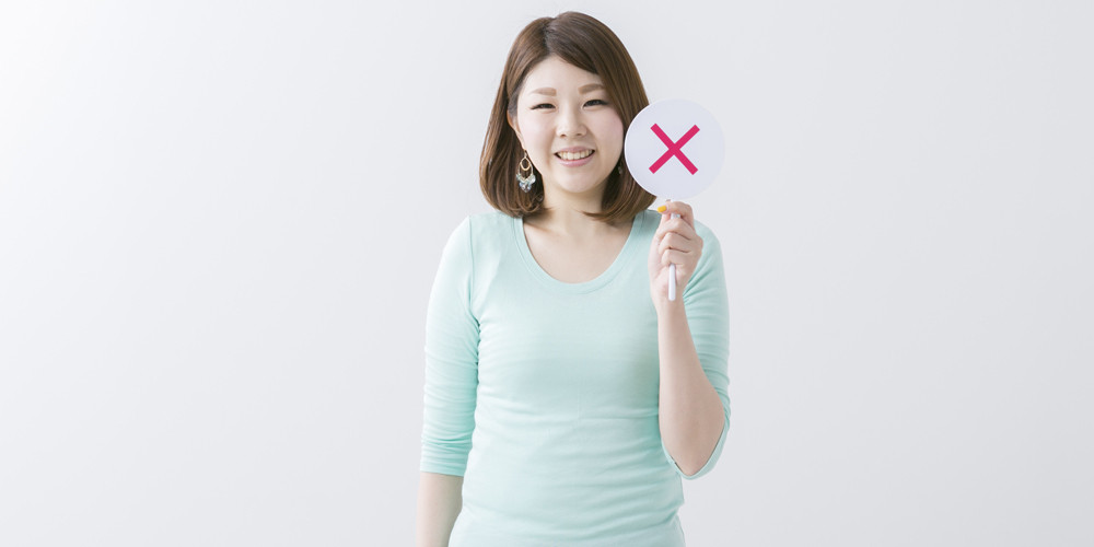 バツマークを出す女性