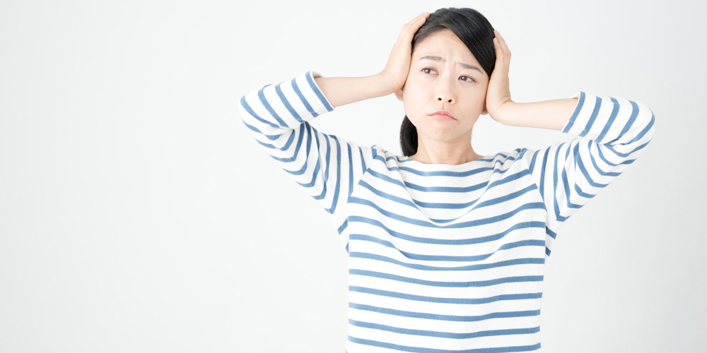 頭を抱えて困る女性