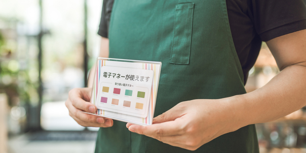 電子マネー支払いの表を見せる店員