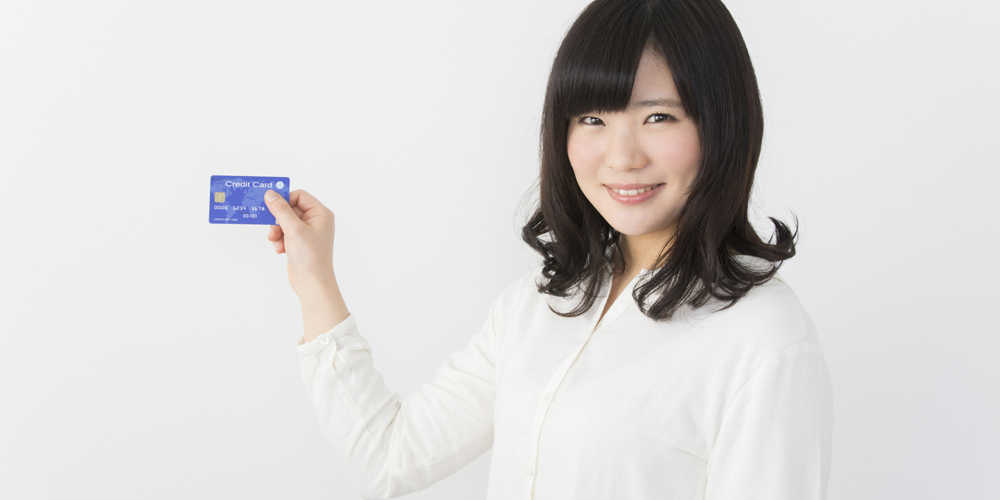 クレジットカードを見せる女性
