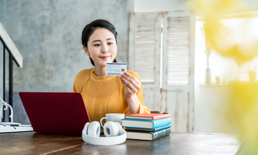 クレジットカードを見つめる女性