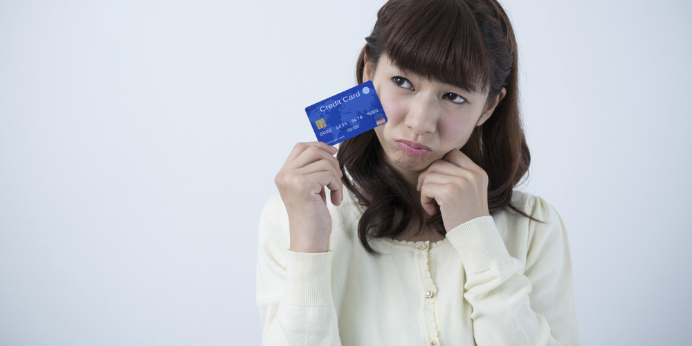 クレカを持って困っている女性