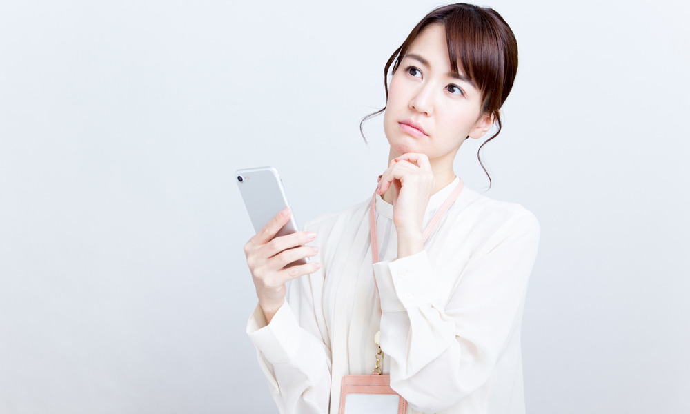 スマホを持って首をかしげる女性