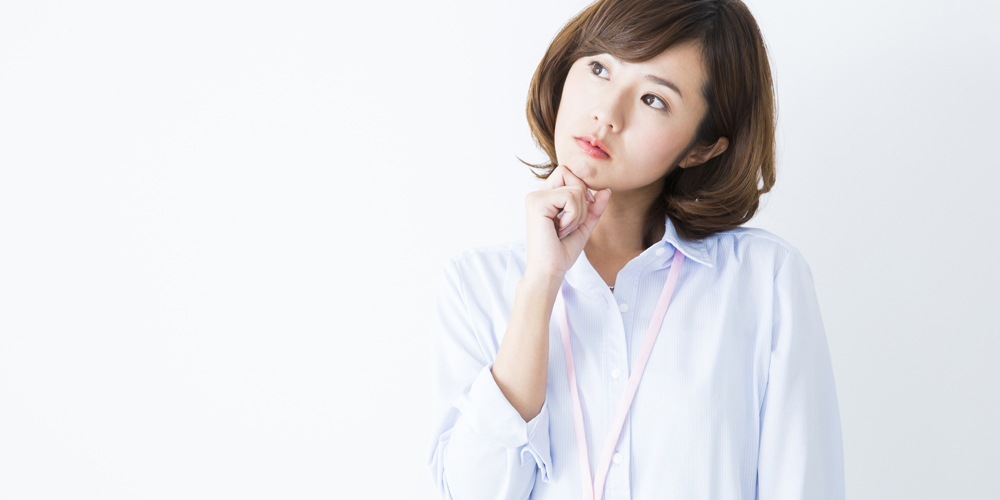 首を傾げて悩んでいる女性