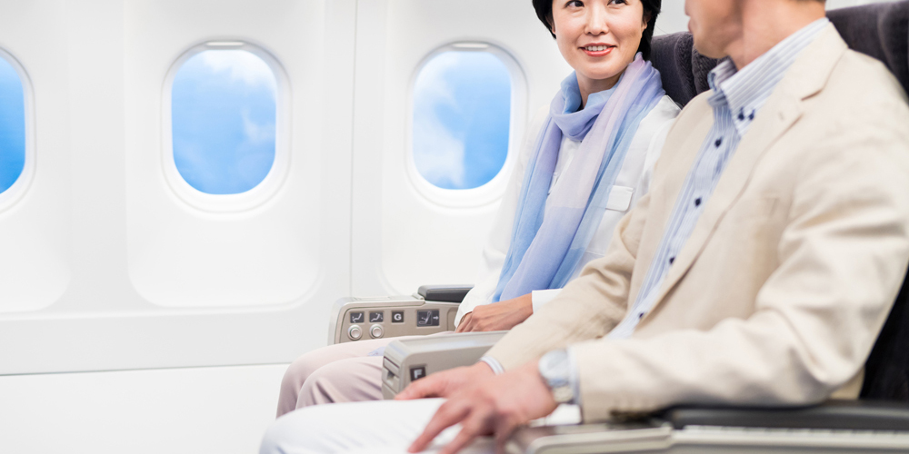 飛行機の機内で会話する夫婦