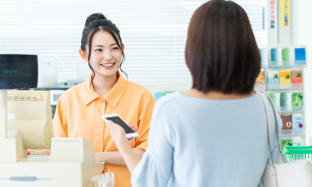 コンビニで電子決済する女性