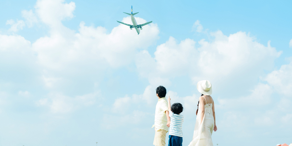 飛行機を見上げる親子