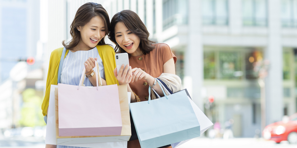 ショッピングしながら雑談する若い女性二人