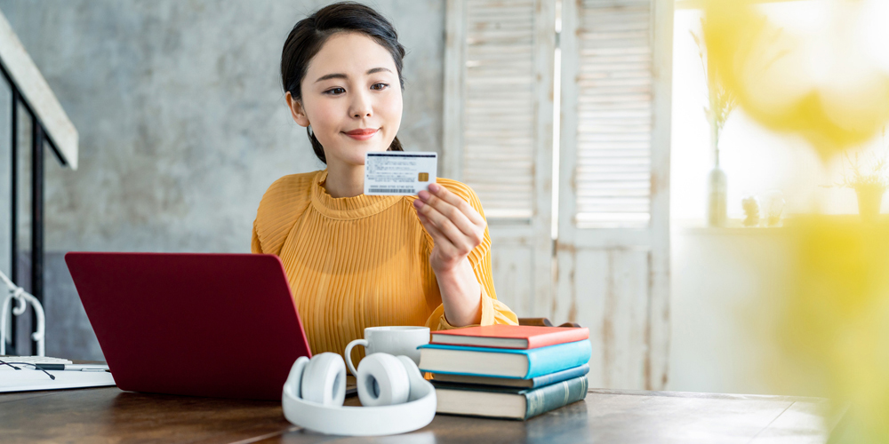 クレジットカードを見つめる女性