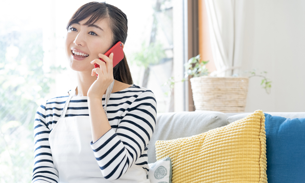 携帯で電話している主婦