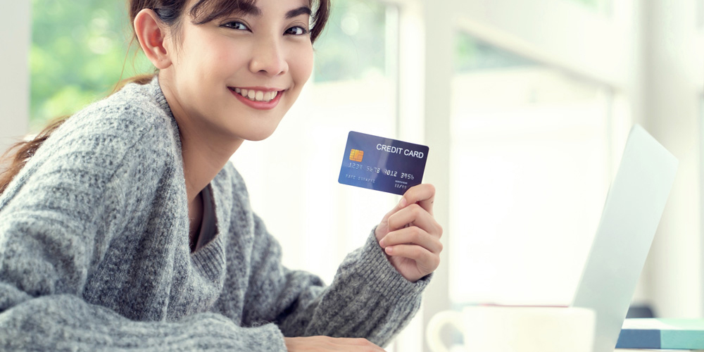 カフェでクレジットカードを持つ女性