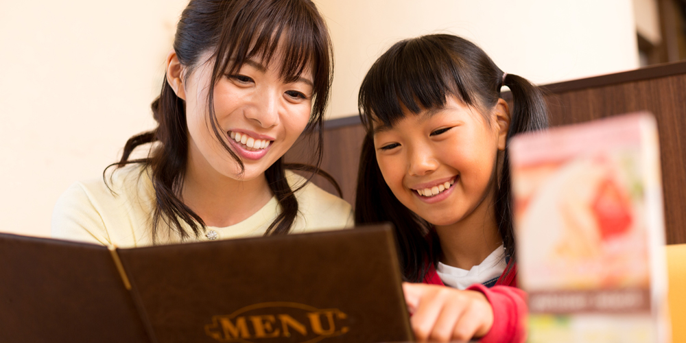 レストランでメニューを見る母娘