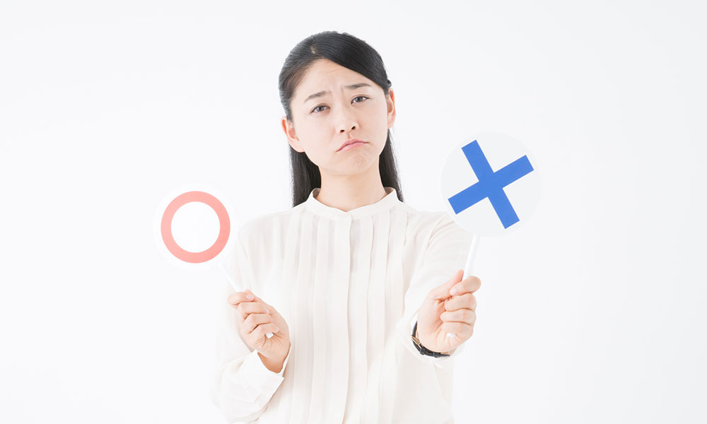 丸とバツを掲げる女性